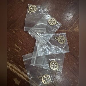 Five golden Tory Burch charms